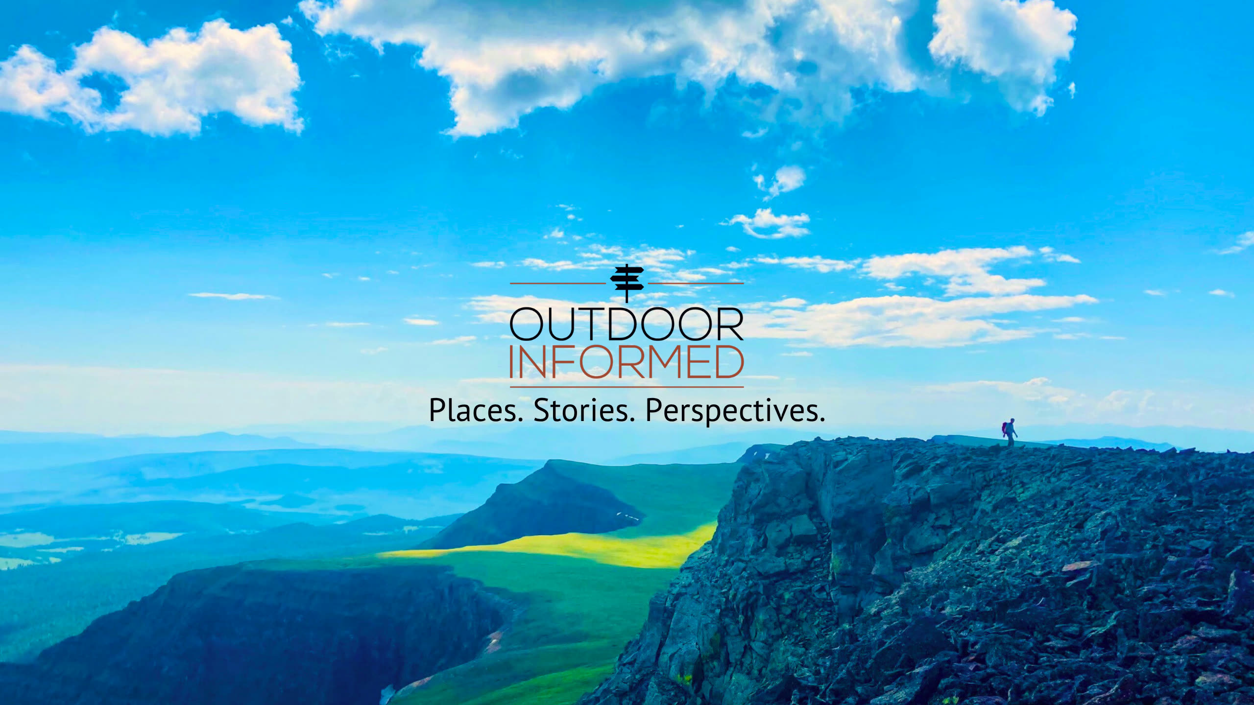 Outdoor Informed: Places. Stories. Perspectives. A hiker stands on a rocky ridge above green valleys in the Colorado mountains.